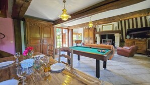 Amplia sala de estar con mesa de billar, muebles de madera y chimenea.