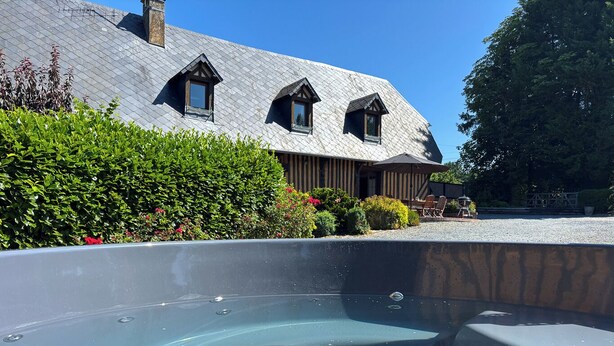 Una piscina con vista despejada a un edificio de techo inclinado y múltiples ventanas.