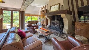 Una sala de estar acogedora con chimenea, sofás de cuero y una televisión.