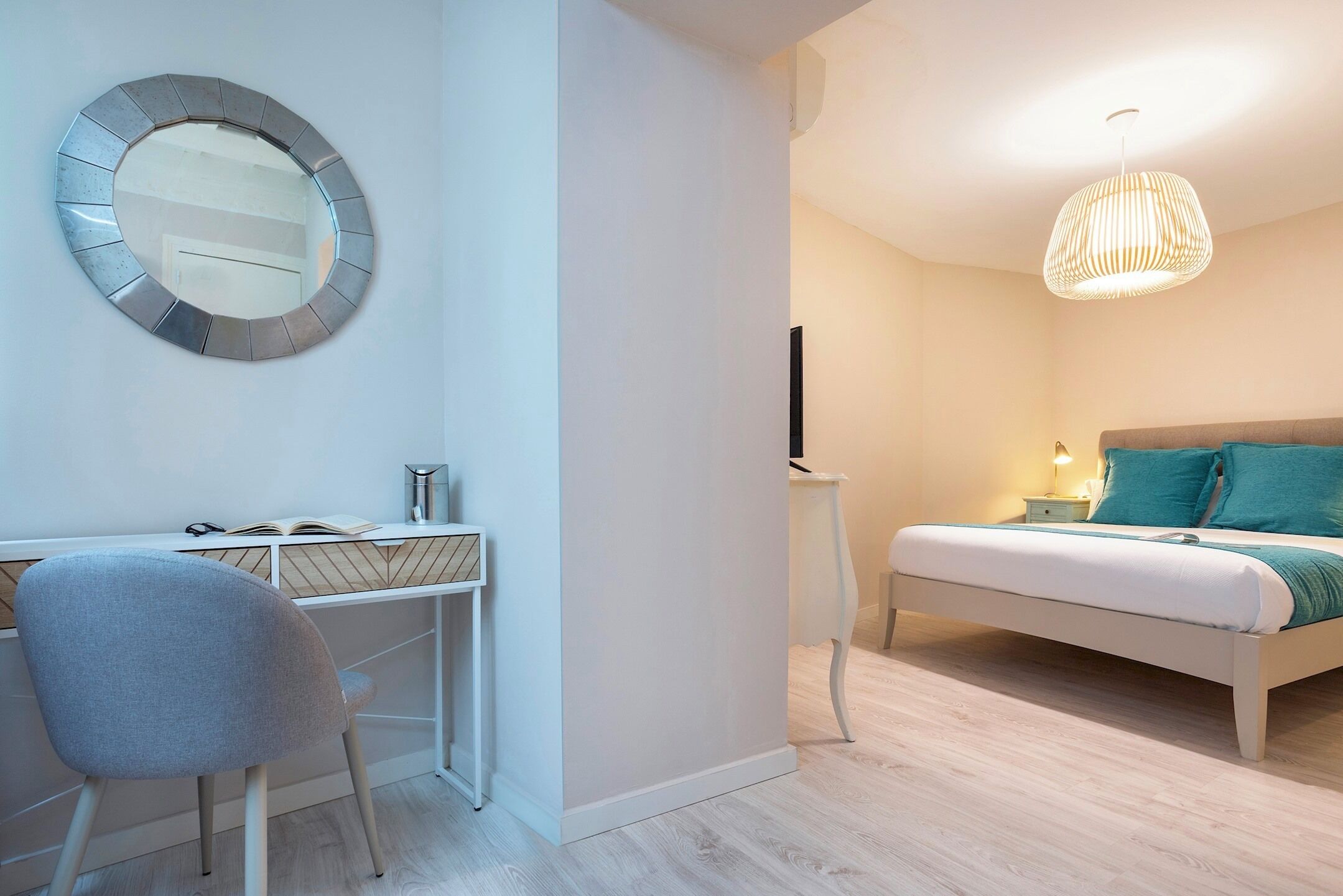 Un dormitorio moderno con cama, mesita de noche y escritorio con silla.