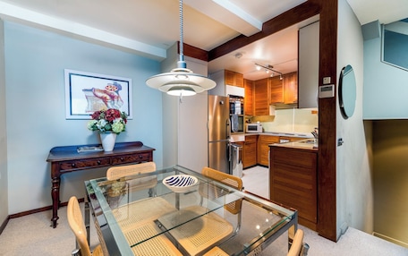 A modern kitchen with wooden cabinets, a stainless steel refrigerator, and a microwave.