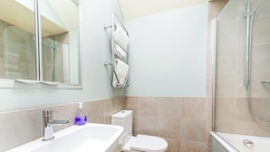 Ein Badezimmer mit Badewanne, Toilette und Dusche.