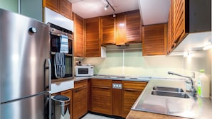 Eine moderne Küche mit Edelstahlgeräten, Holzschränken und einer Spüle aus Edelstahl.