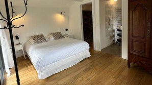 Ein Schlafzimmer mit Bett, Stuhl, Kleiderschrank und einer Tür zu einem anderen Raum.