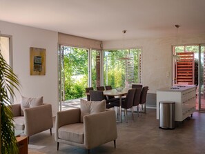 Ein modernes Interieur mit Essbereich, Sitzgelegenheiten und einer Küche.