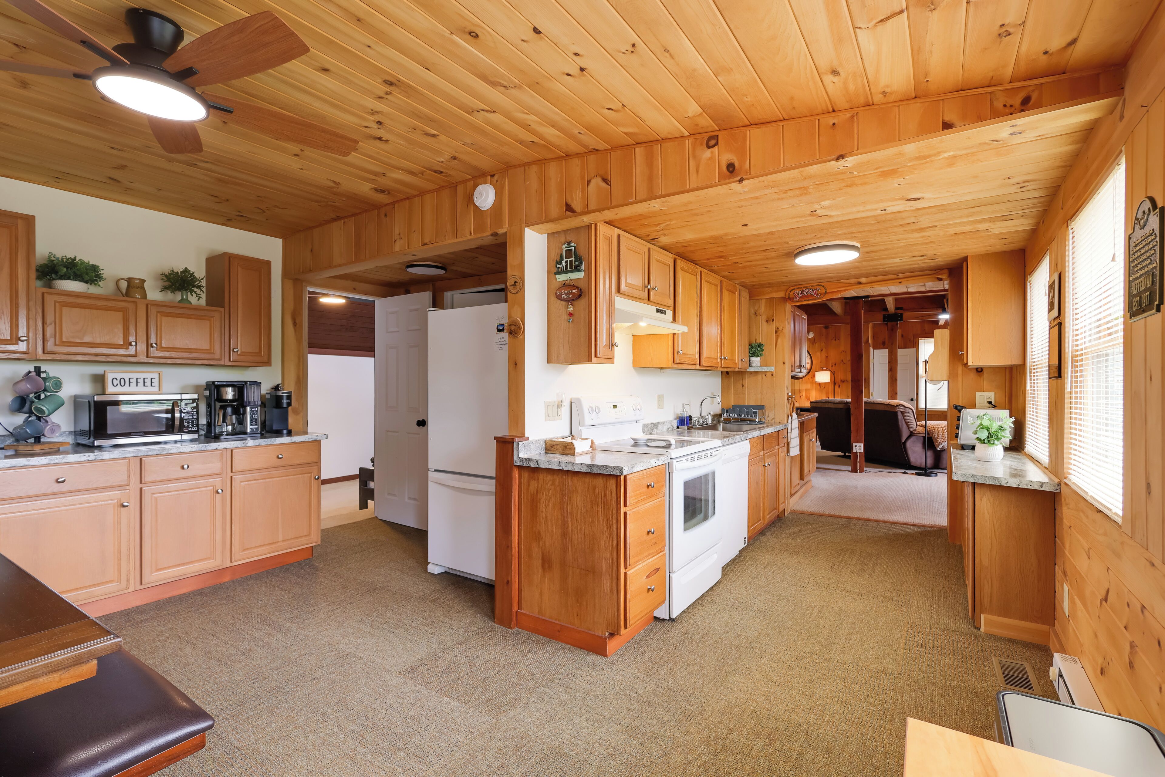 L’intérieur d’une cabane en bois comprend un coin cuisine équipé de meubles en bois, d’un four à micro-ondes, d’une machine à café et d’un réfrigérateur.
