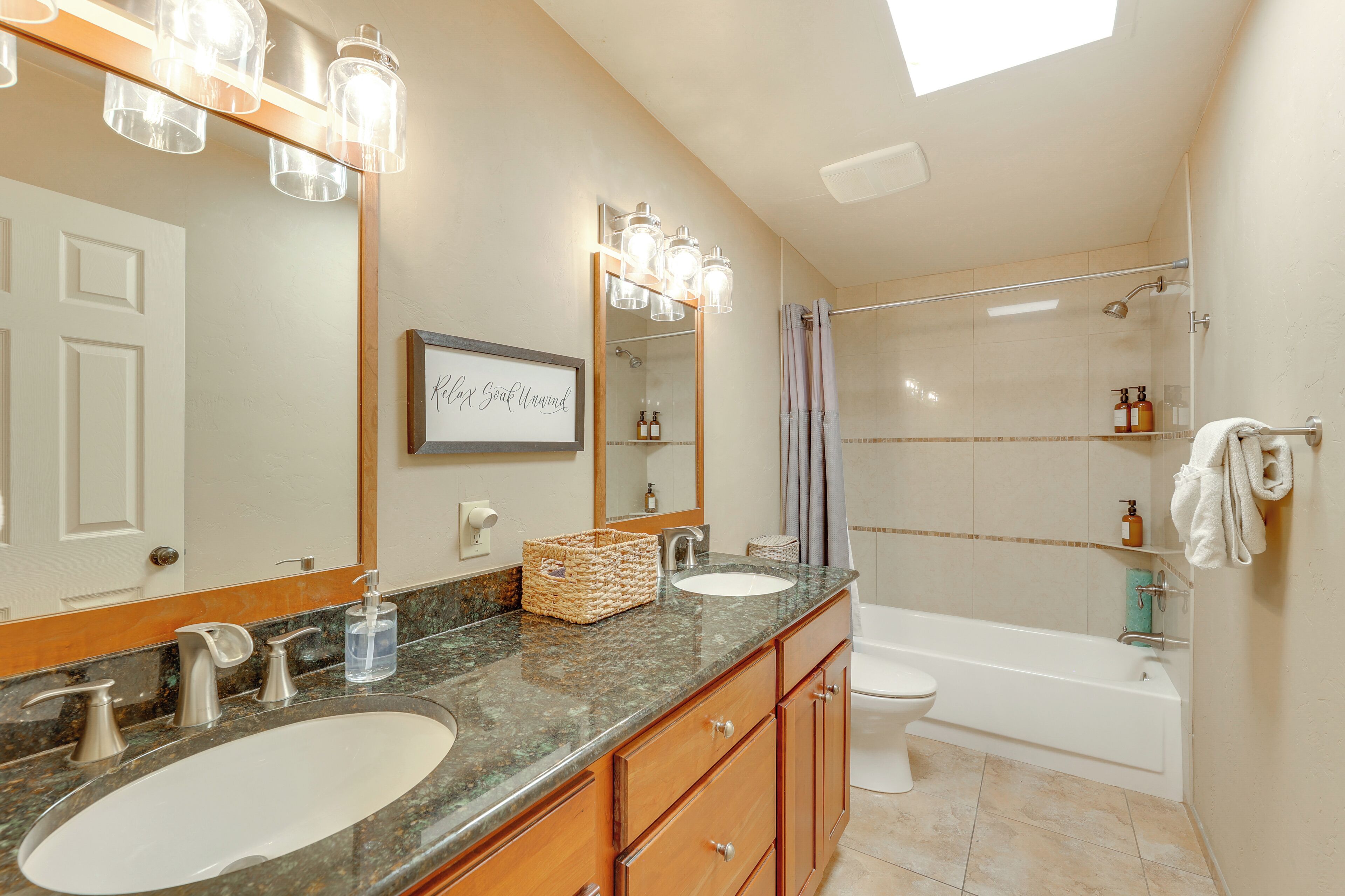 A bathroom with two sinks, a large mirror, and a shower area.