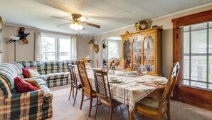 A dining area with a table set for four, surrounded by plaid sofas and wooden chairs. - Pet-friendly Smithmill Retreat w/ Yard! (Houtzdale)