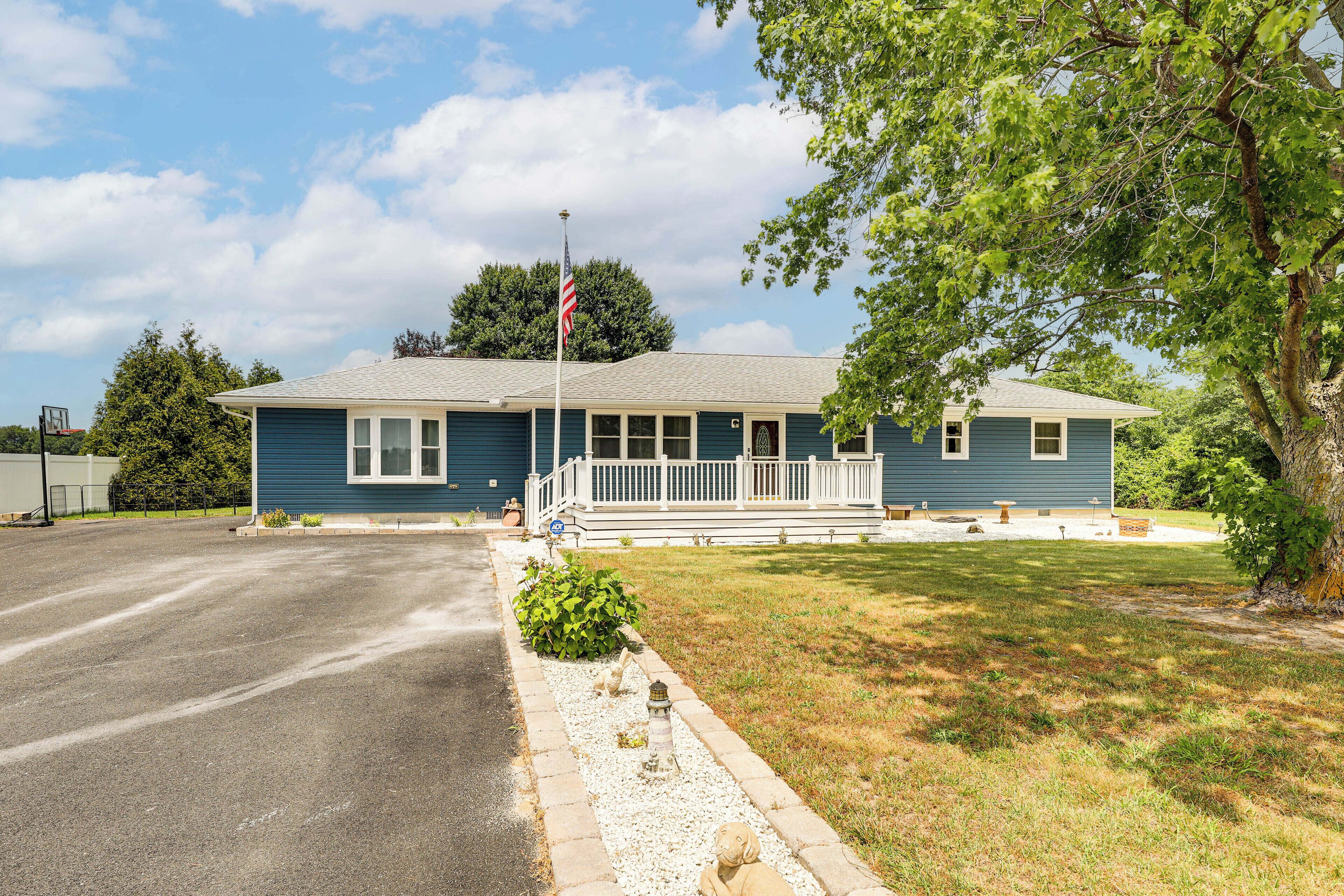 A single-story building with a porch, a flagpole, and a well-maintained lawn.