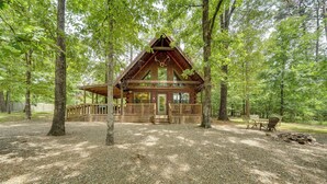 Een chalet met een houten gevel, een veranda en een terras.