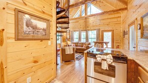 L’intérieur d’une cabane en rondins comprend un coin repas, une cuisine et un salon.
