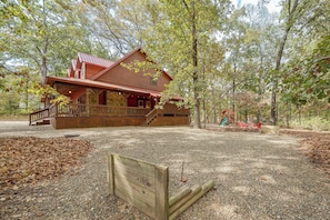 A rustic cabin with a porch, surrounded by trees and a playground. - Near Choctaw Landing 2 King Bedrooms Game Loft (Broken Bow)