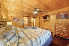 A wooden cabin bedroom with a bed, dresser, and a ceiling fan. - Near Choctaw Landing 2 King Bedrooms Game Loft (Broken Bow)