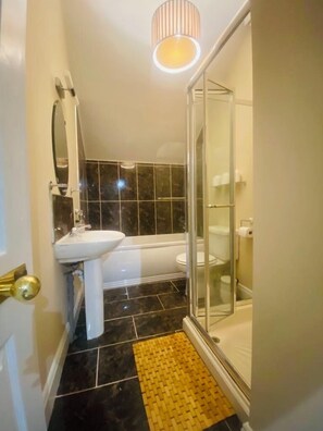 A bathroom with a sink, mirror, toilet, and shower. - The Old Boathouse Holiday Cottage on the Shores of Lough Erne-4 Double Bedrooms (Derrylin Enniskillen)