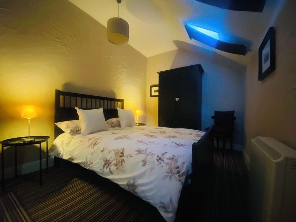 Ein Schlafzimmer mit Bett, Nachttischen, einem Kleiderschrank und einer Heizung.