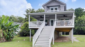 A two-story house with a covered porch and a staircase leading to the upper level. - Riverfront Family Retreat w/ Yard in Saint Amant (Saint Amant)