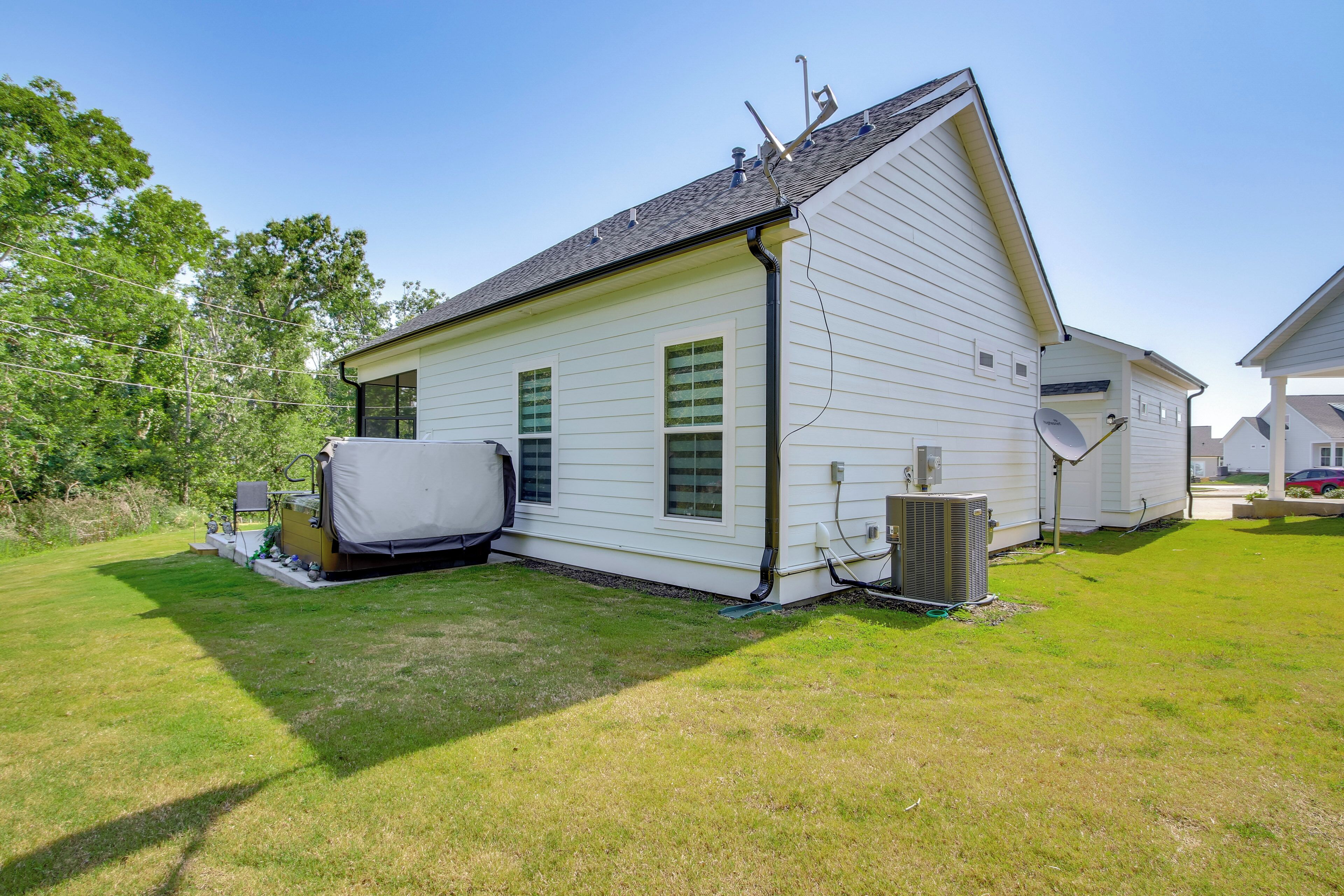 A single-story house with a sloped roof, a covered outdoor seating area, and a satellite dish.