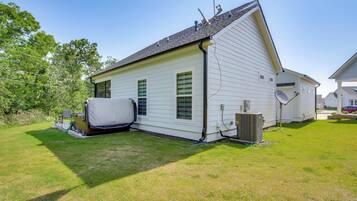 A single-story house with a sloped roof, a covered outdoor seating area, and a satellite dish.