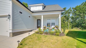 A two-story house with a front porch, a garage, and a well-maintained lawn.