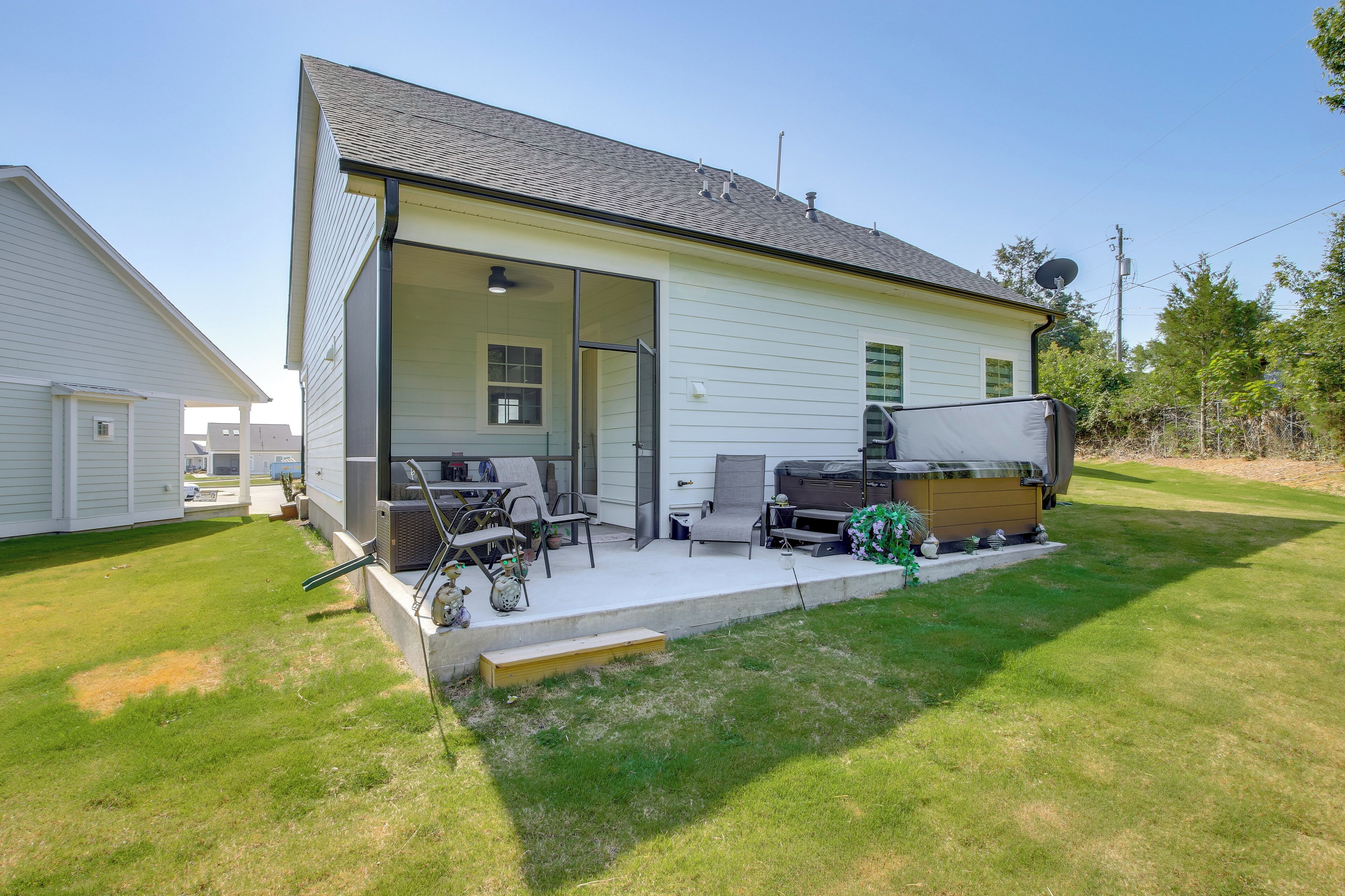 A single-story house with a covered patio area, a grill, and a satellite dish.