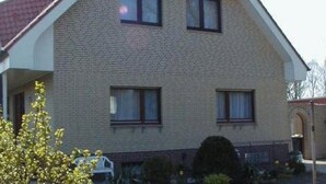 A two-story house with a gabled roof, a brick facade, and multiple windows. - Apartment 'Einzelzimmer' with Wi-Fi (Cuxhaven)