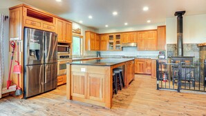 A spacious kitchen with wooden cabinets, stainless steel appliances, and a central island. - Brian Head Cabin < 1 Mi to Resort: Ski + Mtn Bike (Brian Head)