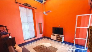 A living room with a sofa, a television, and a window. - Nok Charming Colonial Villa Ctg (Cartagena)