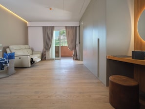 Suite, vista città | Area soggiorno | TV a schermo piatto 80 cm con canali via cavo