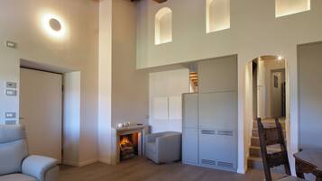 Un intérieur moderne avec une cheminée, des sièges et un escalier menant à un niveau supérieur.