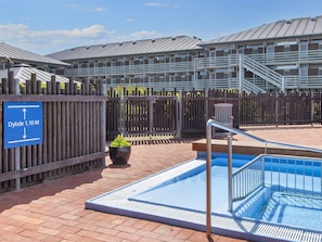 A swimming pool with a metal railing, a wooden fence, and a sign indicating the direction to the Dybbes. - 4 Person Holiday Home on a Holiday Park in Fano (Fano)