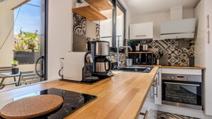 Une cuisine moderne équipée d’une machine à café, d’un évier et d’une cuisinière.