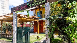 A building with a sign reading "ALMA BRAVA" and a wooden pergola entrance. - Pousada Alma Brava (Itajai)