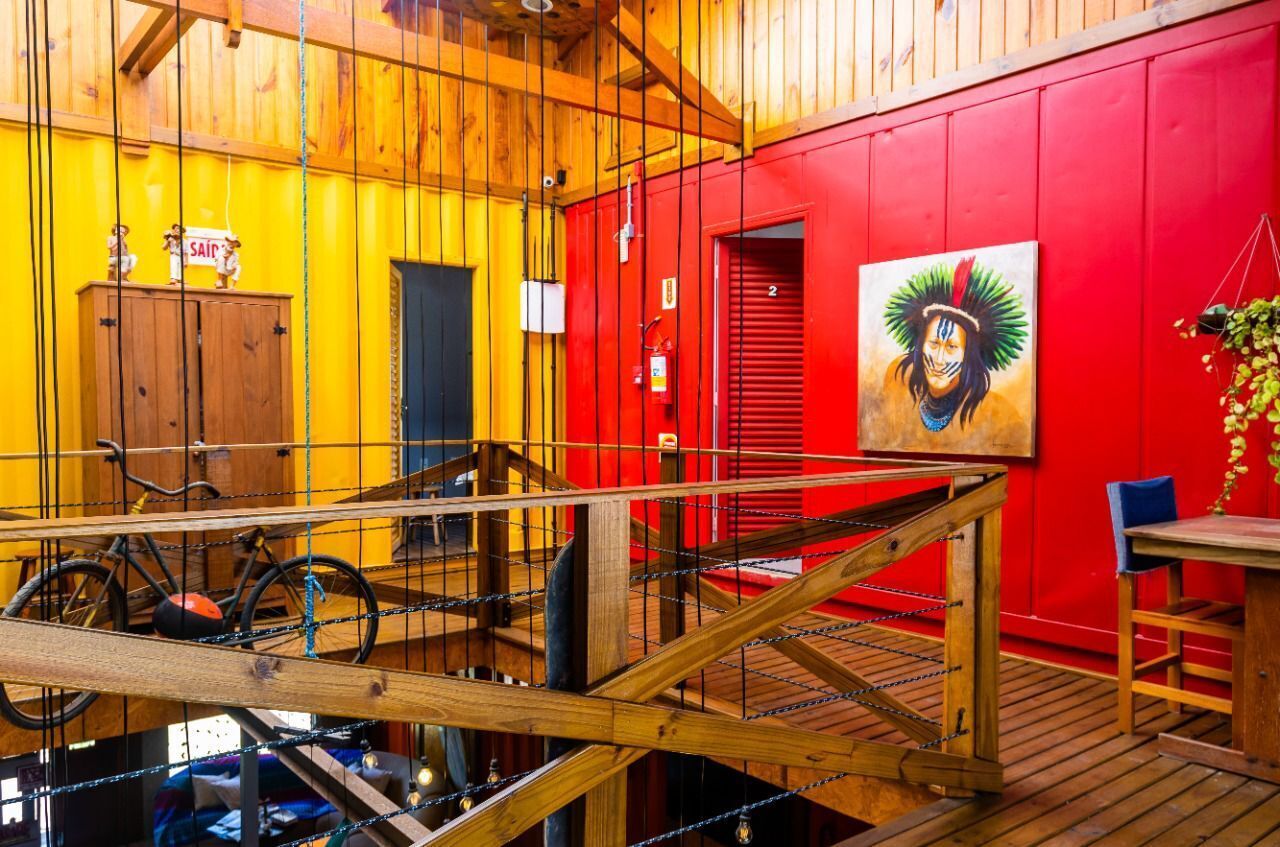 Un interior de madera con una pared roja, un cuadro y un soporte para bicicletas.