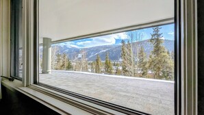 A window with a view of a snowy mountain landscape and trees. - Mountain views, spacious, trails, shared hot tub (Keystone)