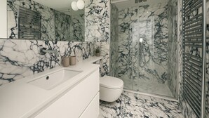 A modern bathroom with a marble sink, toilet, and shower. - Studio moderne a Opera (Paris)