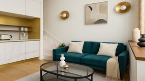 A modern living room with a teal sofa, a glass coffee table, and a minimalist design. - Studio moderne a Opera (Paris)