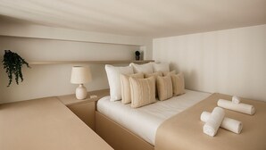 A minimalist hotel room with a bed, bedside tables, a lamp, and a potted plant. - Studio moderne a Opera (Paris)
