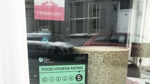 A window display with a food hygiene rating of 5, a 'Very Good' Hotels.com rating, and a 'Rated Excellent' by TripAdvisor. - AYSGARTH HOUSE (Blackpool)