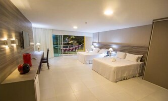 Habitación de hotel con cama, escritorio y silla. Ventana con cortinas y vistas al exterior.