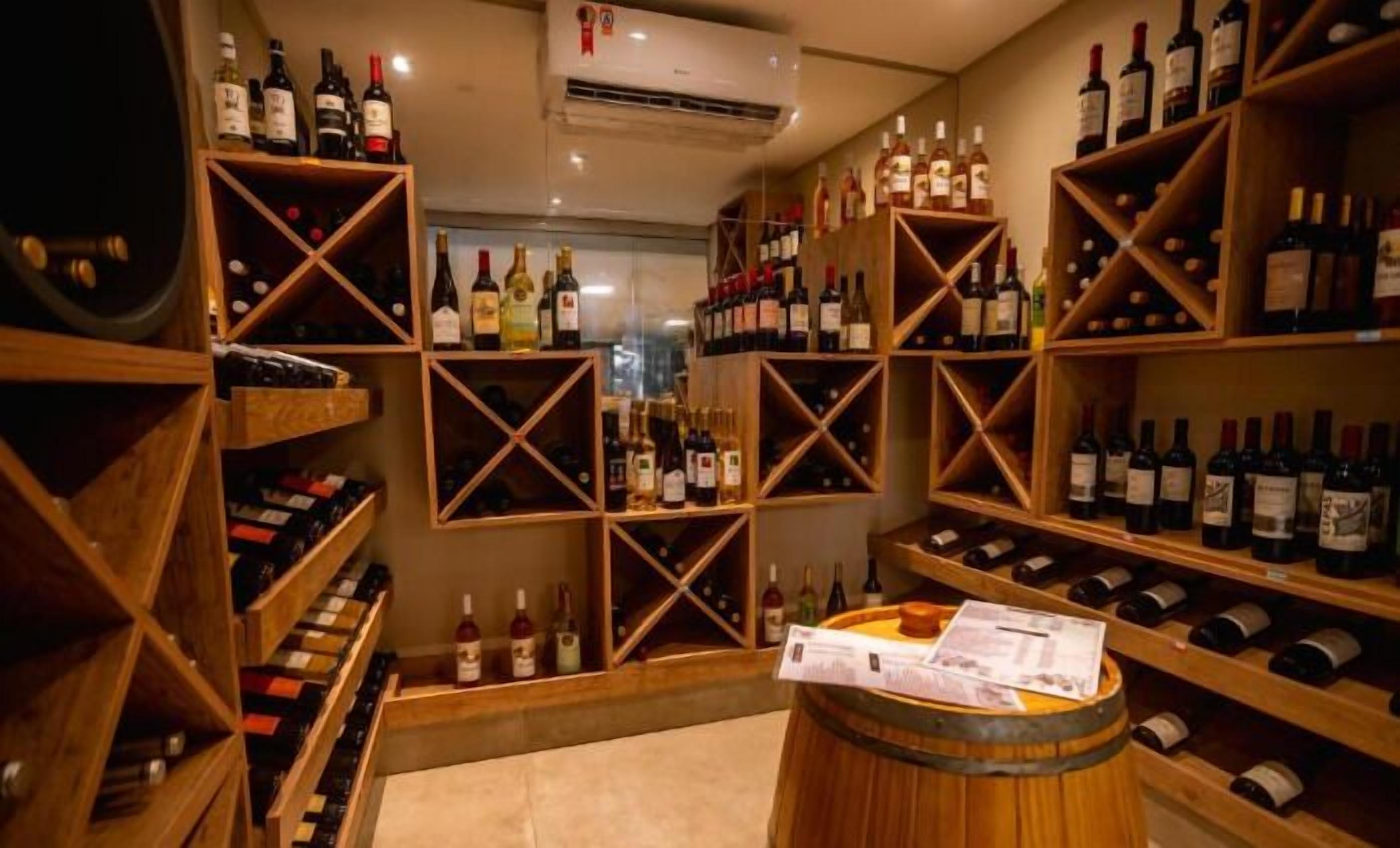 A wine cellar with wooden shelves and racks holding various bottles.