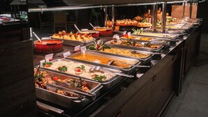 Un buffet proposant une variété de plats, notamment du riz, des pâtes et des salades.