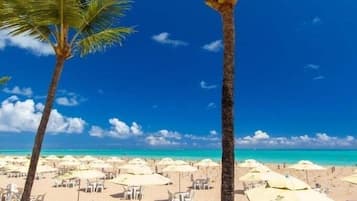 On the beach, white sand, sun loungers, beach umbrellas
