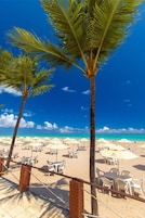 En la playa, arena blanca, sillas reclinables de playa, sombrillas