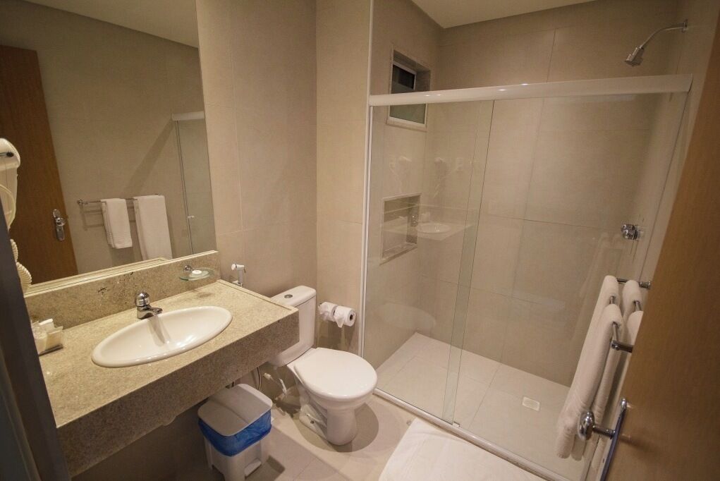 A modern bathroom with a sink, toilet, and glass-enclosed shower.