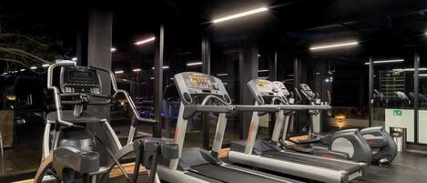 A gym with treadmills, elliptical machines, and a stationary bike.