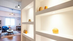 A modern living room with a blue sofa, a coffee table, and a bookshelf with decorative items. - Alex's 2-Bedroom Apartment in Athens (Athens)