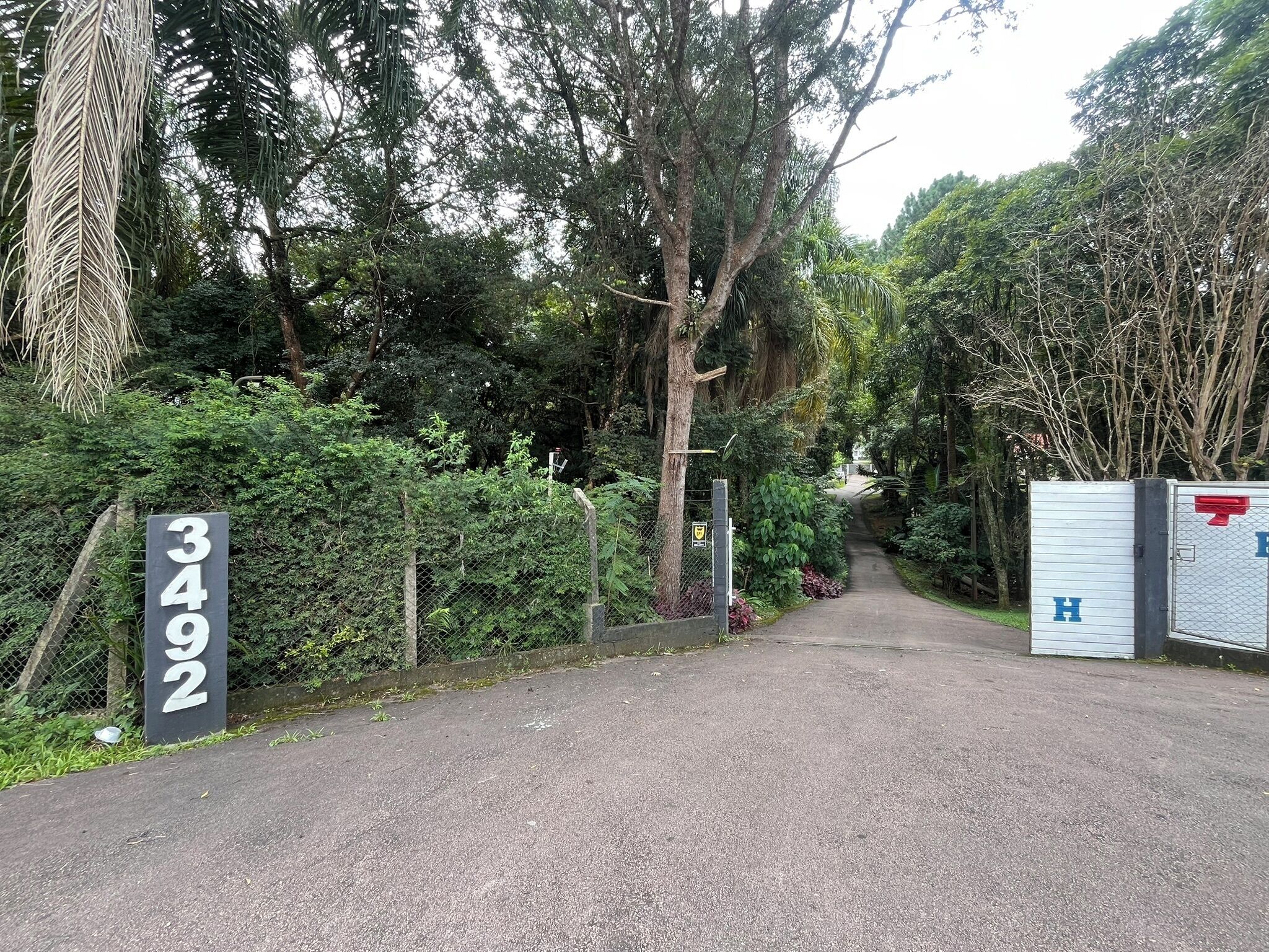 Uma trilha leva a uma área murada com uma placa exibindo o número 3492.
