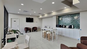 A modern interior with a dining area, kitchen, and seating space. - Sunny Sands | Cozy, Beachfront Condo (Galveston)