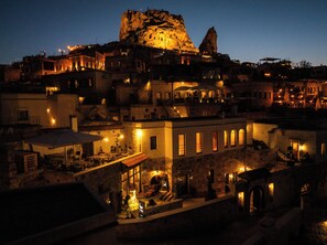 A historic town with illuminated buildings and a prominent rock formation. - Cybele in Cappadocia (Nevsehir)