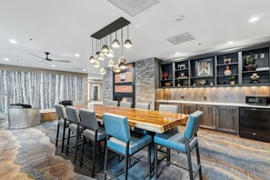 A modern kitchen with a built-in microwave and a dining area with a wooden table and chairs.